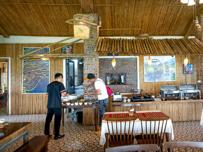 The interior of a cozy, rustic restaurant with a strong bamboo and brick design theme