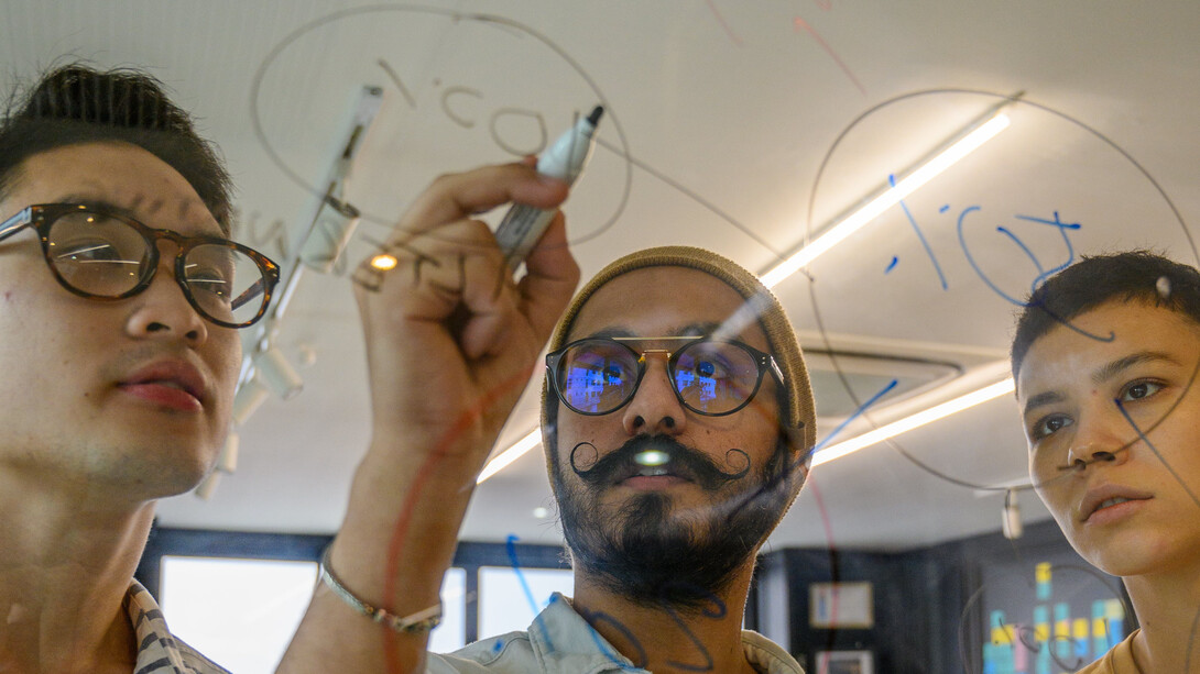 Analista estudam estratégia de Blockchain em lousa de vidro