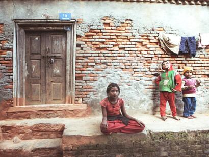 A rural scene from Haldwani, India, where people gather in front of a building—capturing the challenges of poverty and unequal access to resources
