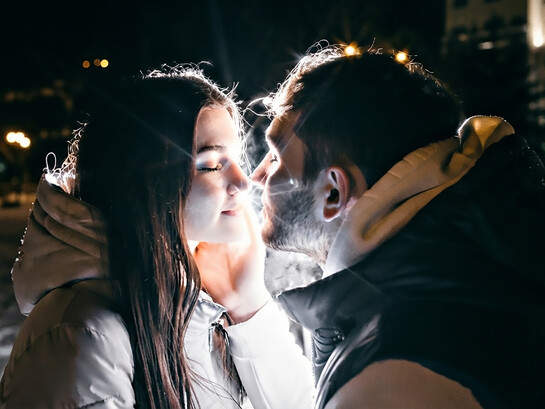 A loving couple embraces tenderly on a cold winter evening