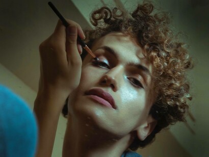 A trans woman who is part of the LBGTQ+ community is applying makeup and ready to go out