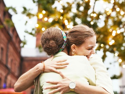 Two friends smiling and hugging as a sign of giving thanks and caring for one another
