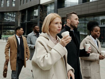 A diverse group of coworkers walks together during a coffee break, reflecting an inclusive workplace environment