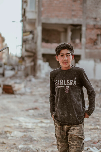 A boy standing amid the rubble of destroyed buildings in Syria