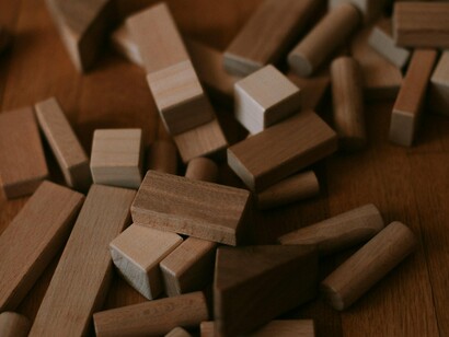 Scattered building blocks strewn across the ground, representing the dismantling of an old world order awaiting reconstruction
