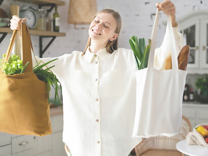 A woman chooses to utilize sustainable fabric bags in lieu of conventional shopping bags