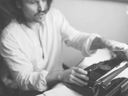 A writer warming up the typewriter as he gets ready to write his next poem