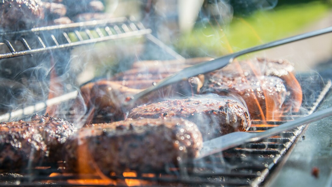The sizzling fat dripping from the meats of a barbecue
