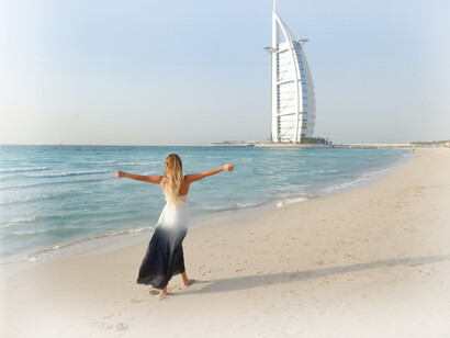 A woman on the beach with the Burj Al Arab in the background, Dubai, United Arab Emirates