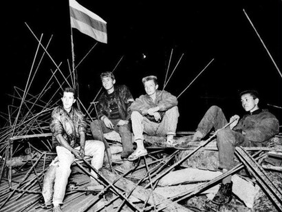 Unos jóvenes se sientan bajo una bandera rusa en una barricada ante la Casa Blanca rusa, en el corazón de Moscú, el 20 de agosto de 1991 de madrugada. Foto: Alexander Nemenov

