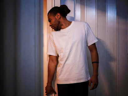 Anxious man in the kitchen, experiencing OCD-driven intrusive thoughts and engaging in compulsions