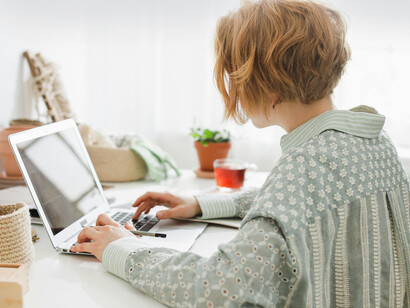 Una señora usando su computadora para consultar sobre unos síntomas. En un primer momento, la Inteligencia Artificial solo analizaba datos masivos
