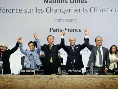 Christiana Figueres, Ban Ki Moon, Laurent Fabius y François Hollande levantan los brazos celebrando los resultados del Acuerdo de París de 2015