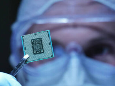 Inside a cutting-edge electronics manufacturing facility, a sterile-suited engineer examines a microchip enhanced with holographic interfaces, reflecting organ-on-chip innovation