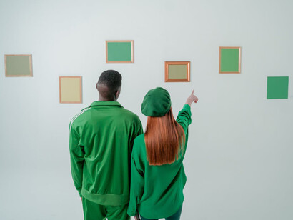 Coppia vestita di verde in ammirazione di opere d'arte