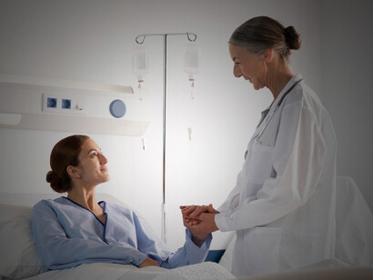 Medical staff preparing and administering intravenous medication to a patient in a clinical setting