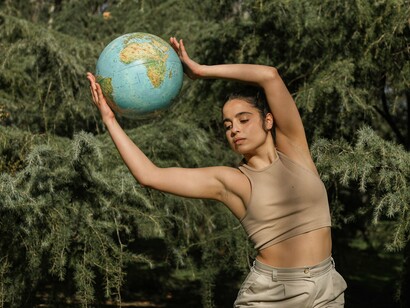 A composição une o corpo humano, a floresta e a representação do planeta em um único gesto simbólico. O texto resgata Gaia como expressão da consciência planetária e do pertencimento de todos os seres à mesma Terra