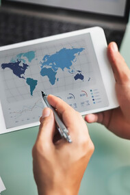 Economists analyzing data on a screen filled with global charts