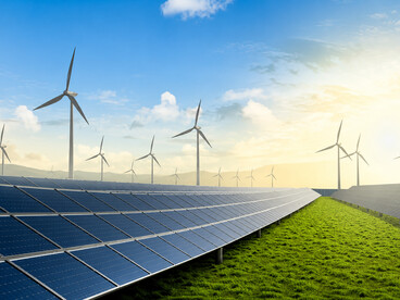 Solar panels and wind turbines working together to produce low-carbon electricity from natural resources
