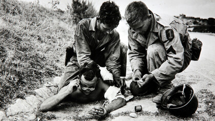 Soldati americani curano un compagno ferito, Sicilia 1943. © Robert Capa © International Center of Photography/Magnum Photos