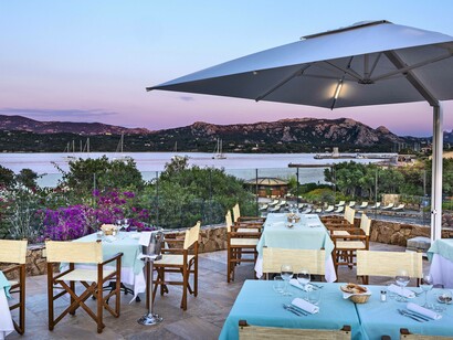 Sunset view of the dinning area at resort Cala di Falco in Cannigione, Italy