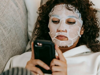 Mulher se distrai ao celular, entediada. As redes sociais, como as neurais, tem um mecanismo binário de ação que é a repetição. Vemos e reproduzimos de forma adaptável, o que está a “dar certo” e como um rebanho, assimilamos as entrelinhas globais com a máscara de “seres pensantes”