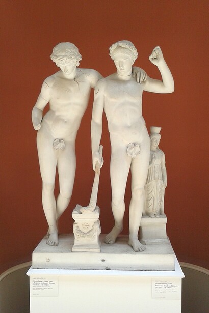 Ofrenda de Pílades, con la cabeza de Antínoo y Orestes. La escultura representa a Orestes y Pílades, amigos legendarios, ofreciendo un sacrificio por haber vuelto de la Táuride con la imagen de Artemisa (estatuilla a la derecha), acto que purificó a Orestes de su castigo divino