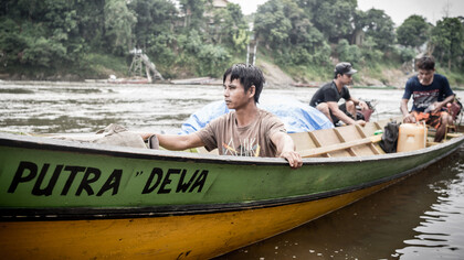 Uomini che attraversano un fiume nella foresta del Kalimantan - Foto di Riccardo Gallino