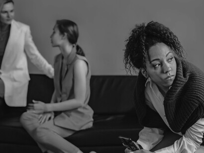 Mesmo cercada por outras pessoas, a mulher mantém a atenção voltada para o celular. A proximidade física nem sempre significa conexão, especialmente quando a interação virtual ocupa o espaço da convivência