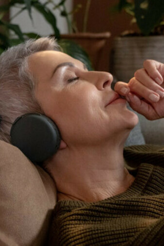 Donna ascolta la voce che proviene dalle cuffie: applicando l’ascolto profondo si è disposti verso l’altro