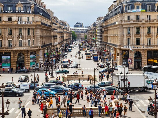 A vibrant European city centre with citizens going about their day, representing the meeting point of public policy, work, and social inclusion