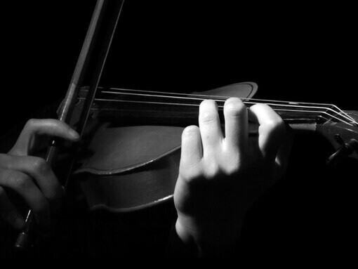 Acercamiento a las manos de una mujer violinista