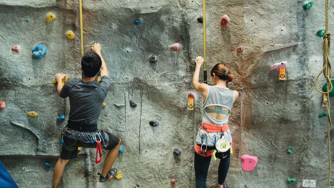 Irmãos competem entre si para escalar uma parede investindo todo o desejo de chegar ao topo
