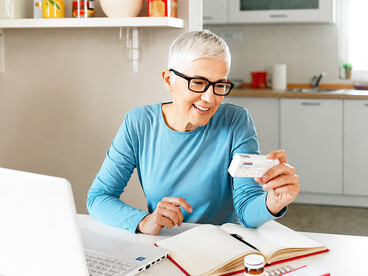 A woman researches information about her medication online while using her computer at home
