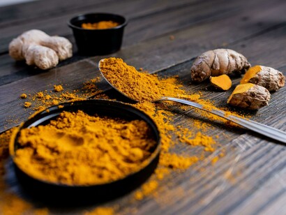 Detailed view of turmeric powder with whole turmeric root