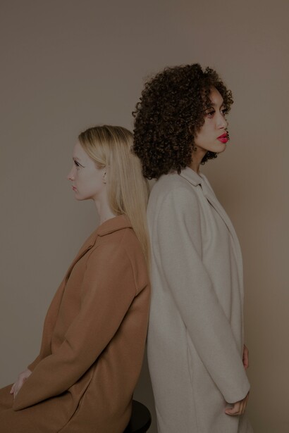Mulheres conflitantes multirraciais em casacos elegantes