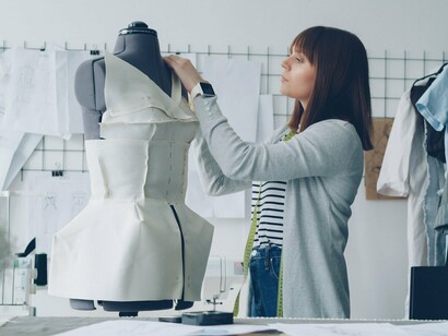 A designer adjusting fabric directly on a dress form, reflecting how sustainable fashion begins with reconsidering the way fabric is shaped and used