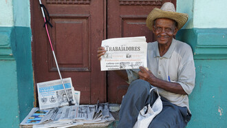 A street vendor selling the *Trabajadores* newspaper in Santiago de Cuba, Cuba