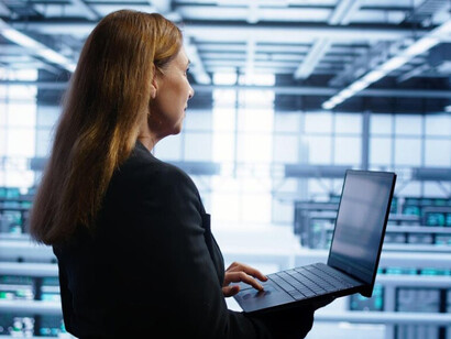 A software developer observes real-time digital systems within a data center environment