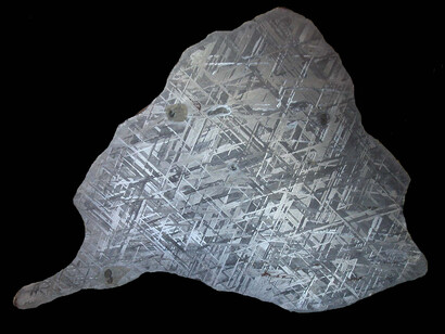 Gibeon endcut black background. A section through an iron meteorite, a natural alloy of iron and nickel. From Gibeon, Namibia
