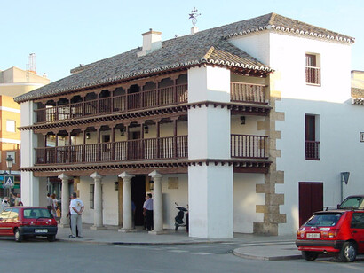 Su fachada está formada por un soportal formado por cuatro columnas toscanas sobre las que se sujetan dos galerías sostenidas por pies derechos y zapatas decoradas con balaustres torneados, al estilo de las corralas o corrales de comedias