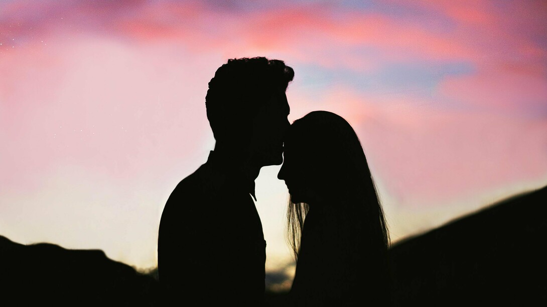 A tender silhouette of two figures in a close embrace against a vibrant sunset sky, symbolizing the profound intimacy and soul-level trust achievable when individuals navigate relationship fears through Jungian self-awareness and conscious partnership