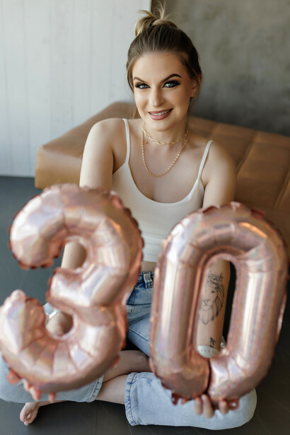 Balões com os números 3 e 0 formam a idade de uma jovem celebrando seu aniversário