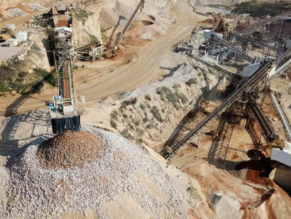 Heavy machinery is at work in an open-pit quarry, driving industrial operations in a surface mine
