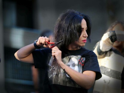 A woman cuts her hair in protest of Iran's treatment of women