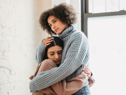 Two friends in each other's arms as they come to terms with the difficult situation they encountered