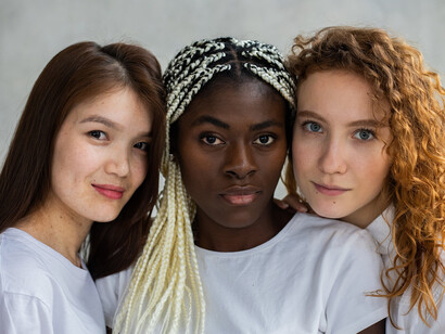 Tre donne posano guardando in camera 