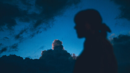 Silueta de una mujer bajo el cielo azul