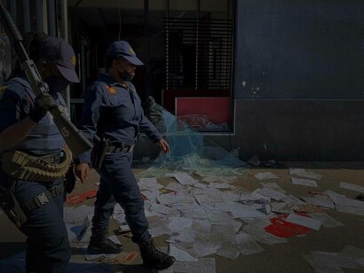 South African police officers patrolling a street that was recently invaded by angry protestors