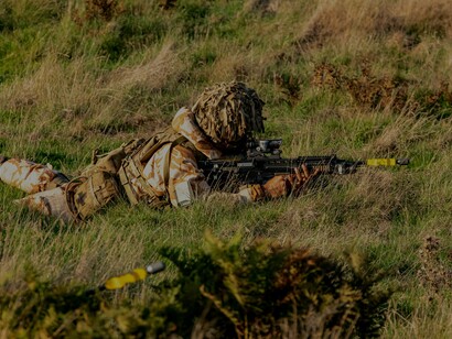 Soldado atirador deitado mirando em seu alvo